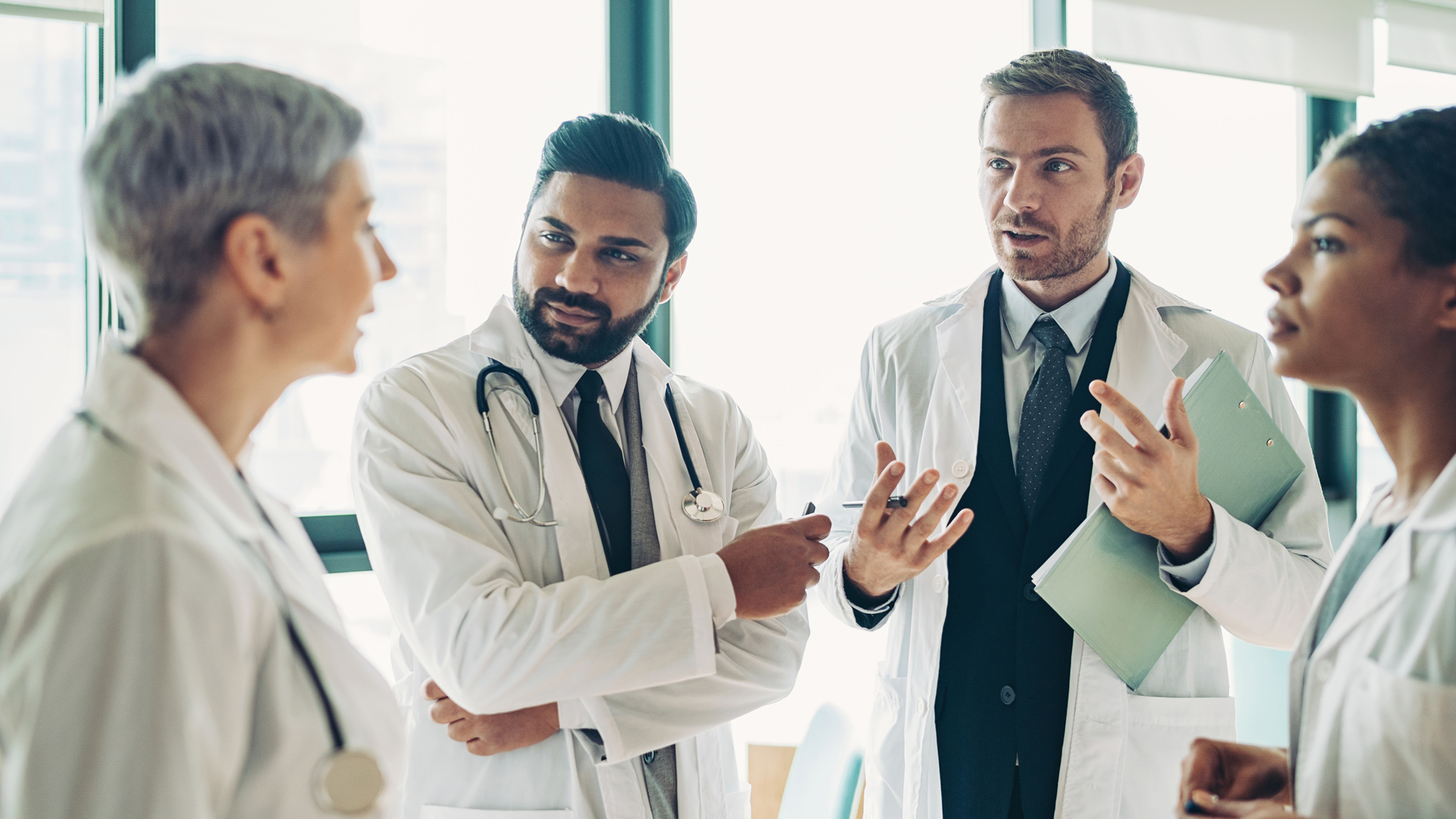 Group of doctors standing in the corridor and talking, m360 research, real-world insights