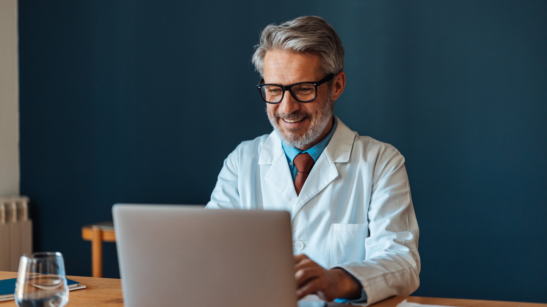 Doctor Working on Laptop with Glasses On, m30 Research, AI in Market Research